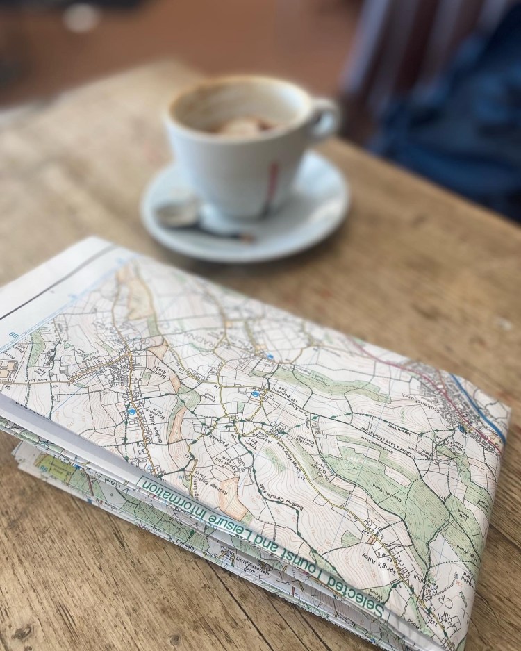 Folded map of the Chiltern hills on the table in a café with a cup of coffee, navigation in the Chilterns Buckinghamshire Oxfordshire area